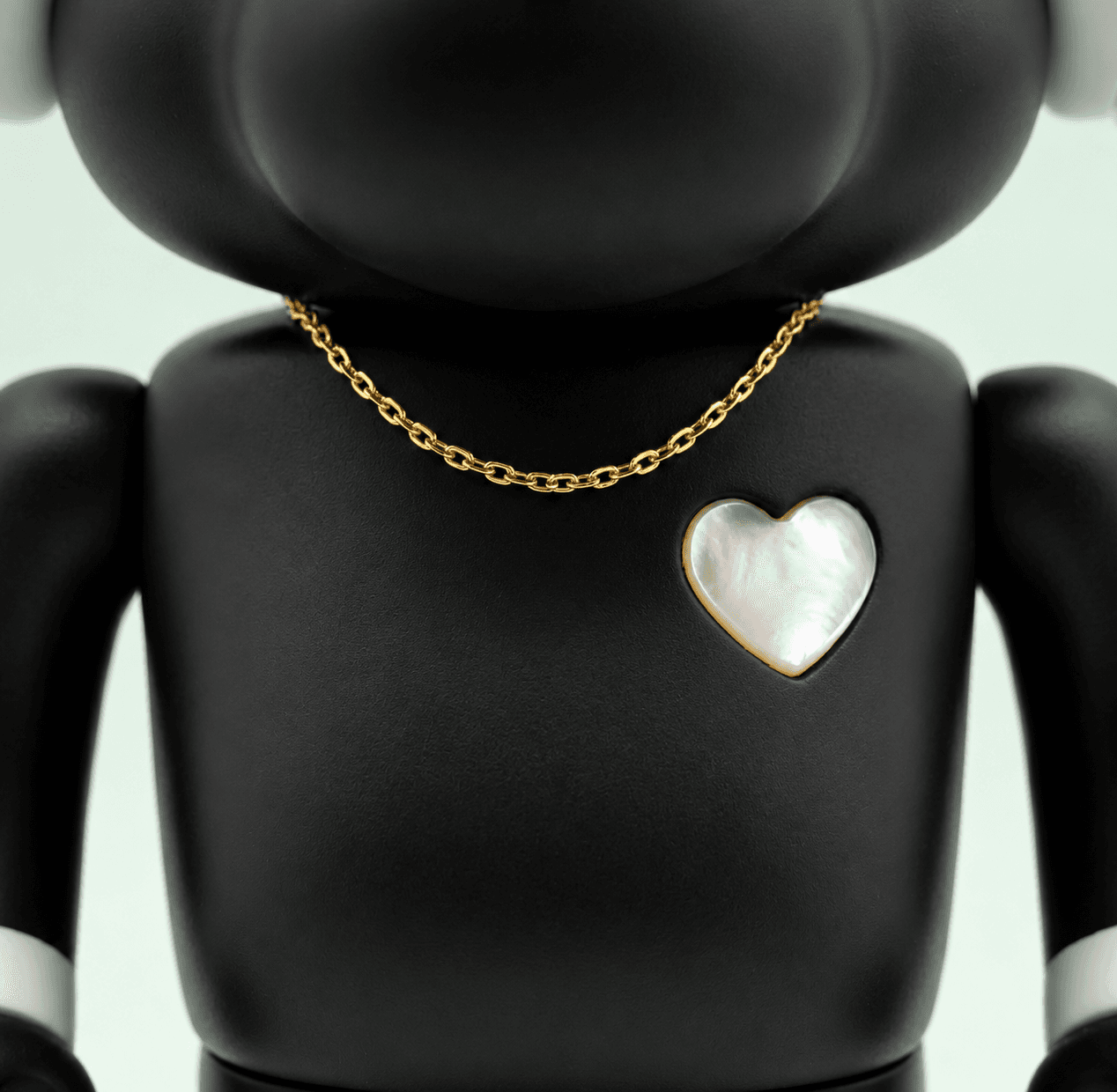 A matte black Happi Buffalo wearing a gold chain, with a mother of pearl heart set into its chest